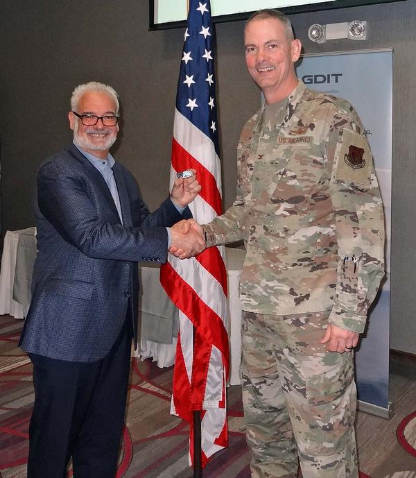 Col. Larry Fletcher, USAF, chapter president (r), shakes hands with Marc Jones, senior vice president, Public Sector Business, CAST Software Inc. Jones was the speaker for the May Luncheon and received a Greater Omaha Chapter coin for addressing the attendees.
