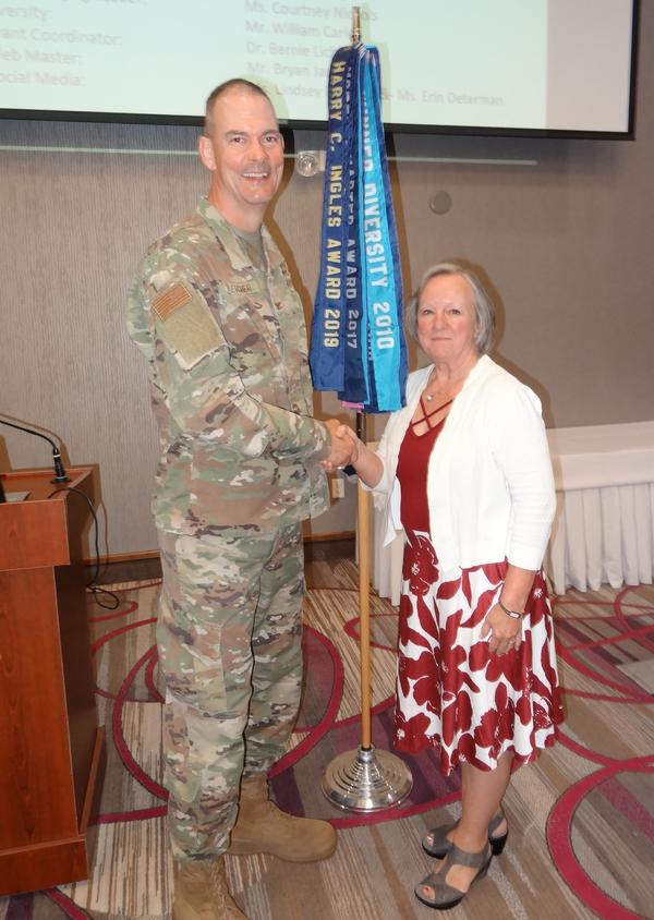 Col. Larry Fletcher, USAF, chapter president (l), shakes hands with Maj. Gen. Jennifer Napper, USA (Ret.), vice president and general manager, Army Business Unit, Peraton, Herndon, Virginia. Gen. Napper was the speaker for the June luncheon and received a Greater Omaha Chapter coin for addressing the chapter.�
