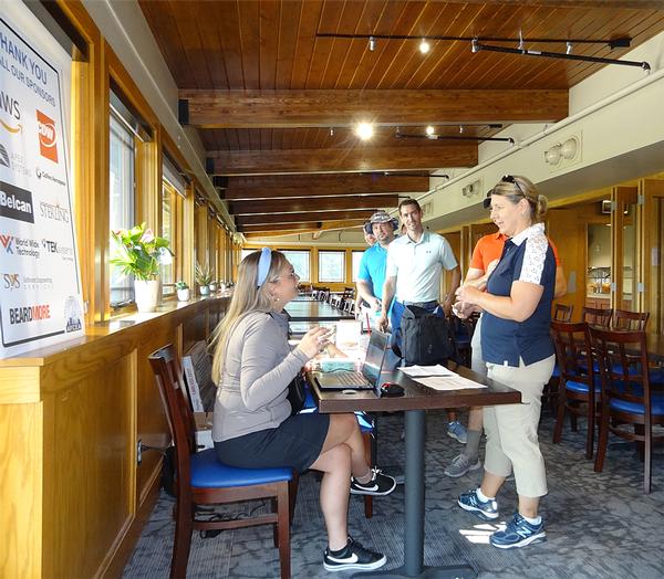 Courtney Nichols, lead Emerging Leader, checks in Kelley Cardinale, Team: Far from Par, at the chapter's 20th Annual Golf Tournament in September.