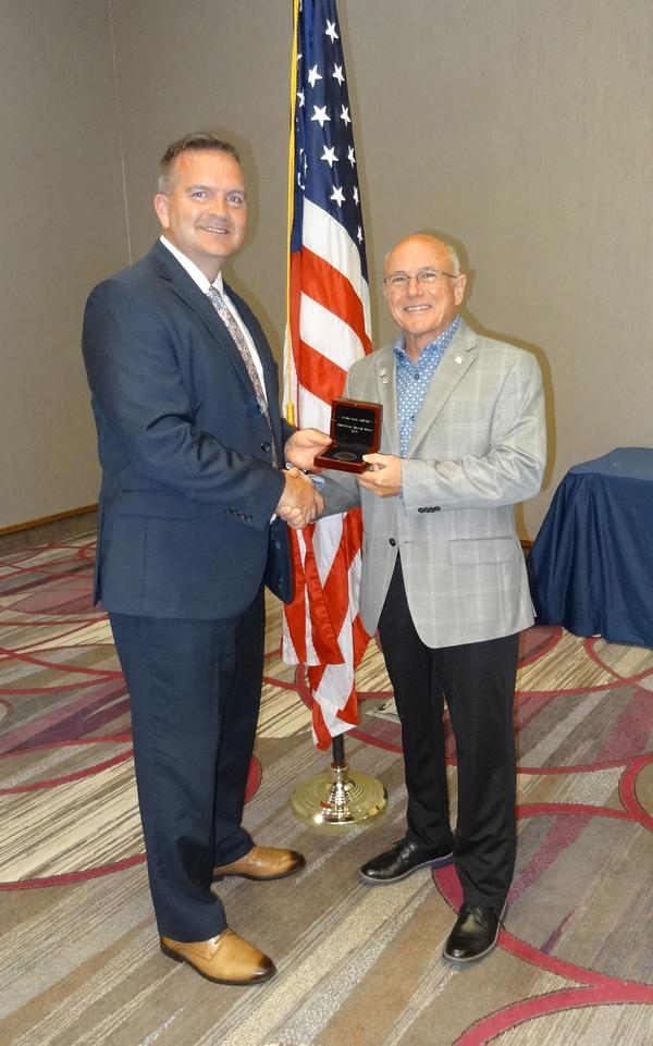 Sean Murphy (l), former chapter president, shakes hands with Michael Varner (r), regional vice president, Great Plains-Rocky Mountain, Colorado Springs, Colorado. Varner presented Murphy with a long overdue award of the AFCEA International Meritorious Service Award for his many years of distinguished service to the chapter.