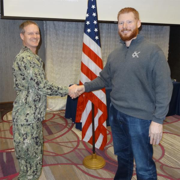 Capt. Thomas Merkle, USN, chapter president (l), shakes hands with Timothy Vidas, principal engineer, Amazon Web Services. Vidas was the speaker for the January luncheon and received a Greater Omaha Chapter coin for addressing the chapter.
