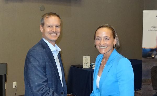 Chapter President Thomas Merkle (l) shakes hands with Amy Gilliland, president, General Dynamics Information Technology, Falls Church, Virginia.  Gilliland shared her thoughts on how to build a culture of innovation within the workplace. She received a Greater Omaha Chapter coin for addressing the chapter in June.
