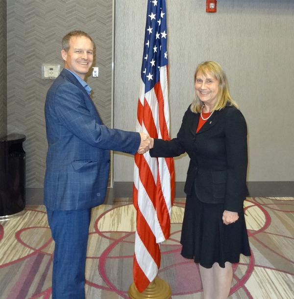 Thomas Merkle, chapter president, shakes hands with Elizabeth Durham-Ruiz, director, Command, Control, Communications and Computer Systems,  and  chief information officer, U.S. Strategic Command (USSTRATCOM), Offutt Air Force Base, Nebraska. Durham-Ruiz shared her thoughts on how USSTRATCOM has embraced artificial intelligence. She received a Greater Omaha Chapter coin for addressing the chapter.