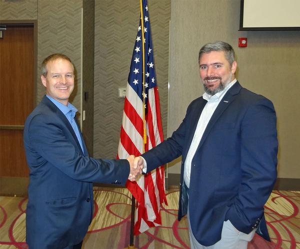Thomas Merkle, chapter president (l), shakes hands with Brandon Bean, solutions director of artificial intelligence/machine learning, General Dynamics Information Technology, Falls Church, Virginia. Bean was the speaker for the October luncheon and received a Greater Omaha Chapter coin for addressing the chapter.
