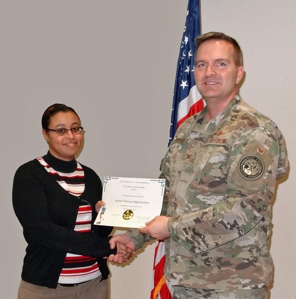 Jessye Chancey-Higginbotham, chapter corporate liaison, shakes hands with Col. Murphy. Chancey-Higginbotham was presented with the chapter's AFCEAN of the Month award for her efforts planning the chapter's Holiday Mixer event.