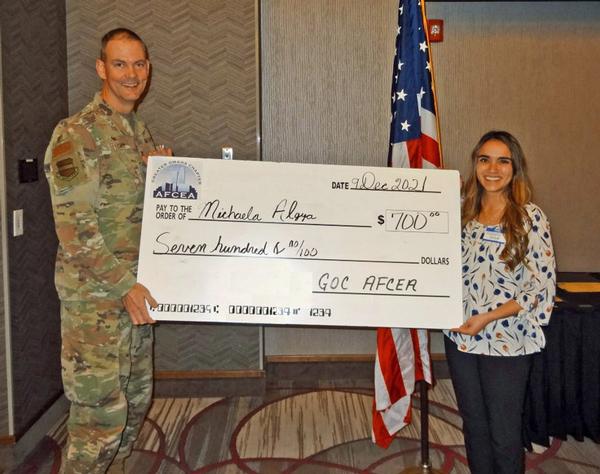 Col. Fletcher presents the big check to Michaela Algya (right), science teacher, grade 8, Lewis and Clark Middle School, Bellevue, Nebraska at the chapter's December event. Algya will procure a variety of science lab and experimentation items to conduct her forensic science program.