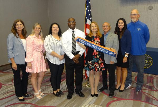 Pictured (l-r) are Erin Determan, chapter social media coordinator; Courtney Nichols, chapter vice president of programs; Diane Campbell, chapter vice president of academics; Gregory Campbell, chapter vice president of publicity; Janel Nelson, chapter president; Varner; Lindsey Briganti, social media coordinator; and Scott Stevens, corporate liaison. Members of the chapter board of directors pose with the RVP while presenting the Model Chapter Award for 2023 and the Member Retention Award for 2023 at the June luncheon. 