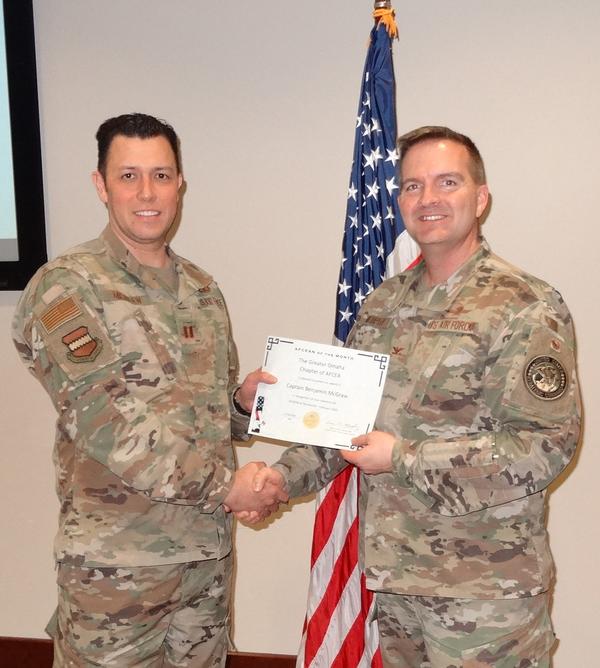 Capt. Benjamin McGraw, USA, chapter vice president of awards (l), shakes hands with Col. Murphy. Capt. McGraw was presented with the chapter's AFCEAN of the Month award for February.