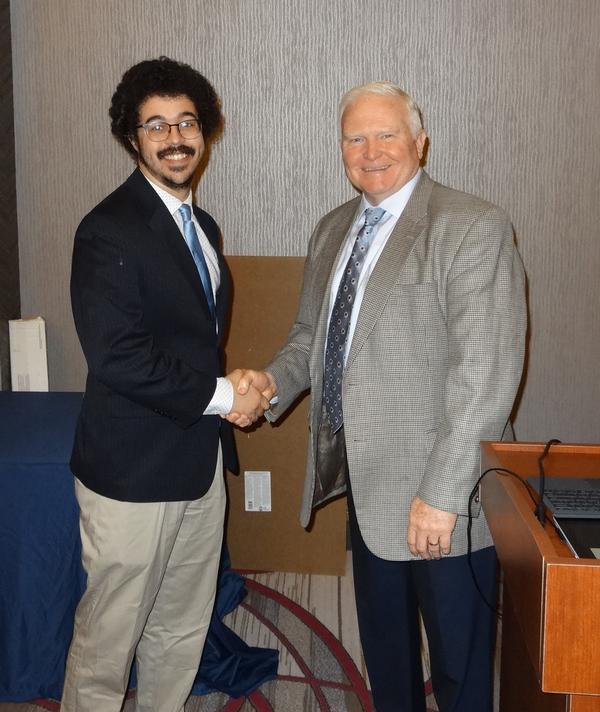 Jordan Higginbotham (l), the chapter's Young AFCEAN lead, shakes hands with Gandy. Higginbotham was the chapter’s emcee for the luncheon and received a chapter coin for his efforts.