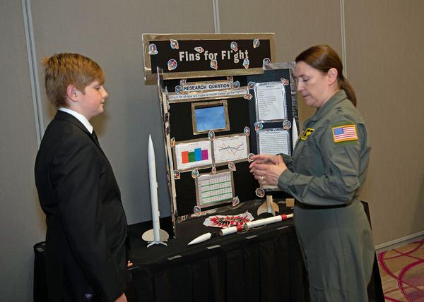 Anthony clarifies a point in Oliver Fondren's science project at the chapter's April luncheon.