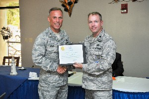 Brig. Gen. Steven Spano, USAF (l), director of communications for Headquarters Air Combat Command, Langley Air Force Base, Virginia, accepts a donation made in his honor to the Keesler Fisher House from Lt. Col. Scott Solomon, USAF, 333rd Training Squadron commander and chapter president. The general served as the keynote speaker at the July meeting.