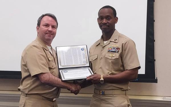 Capt. Brett "T-Rex" O'Donovan, USN, commanding officer of Naval Computer and Telecommunications Area Master Station, Atlantic (NCTAMS LANT)(l), and Lt. Craig McKnight, USN, NCTAMS LANT Transition Team, receive the Cyber Team Award in February.