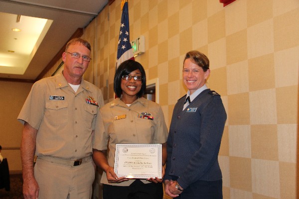 In November, Lt. Cmdr. Doug Vanderlip, USN, chapter president, and Lt. Col. Jenniffer Romero, USAF (r), chapter vice president for military affairs, present Information Technician Systems 1st Class Kwelisha Jackson, USN, with the Military Cyber Professional of the Month Award.