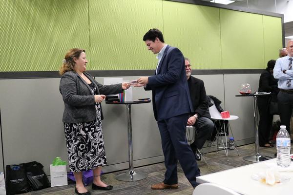 Hillary Boyce, chapter vice president, small business, presents a door prize at the February event.