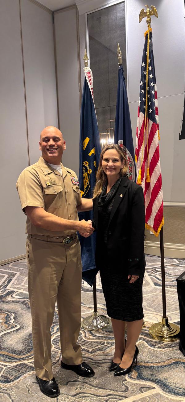 Capt. Brian Conner, USN, commanding officer of Naval Computer and Telecommunications Area Master Station Atlantic (NCTAMS LANT), shakes hands with the new chapter president, Kelly Jenne, at the January event.