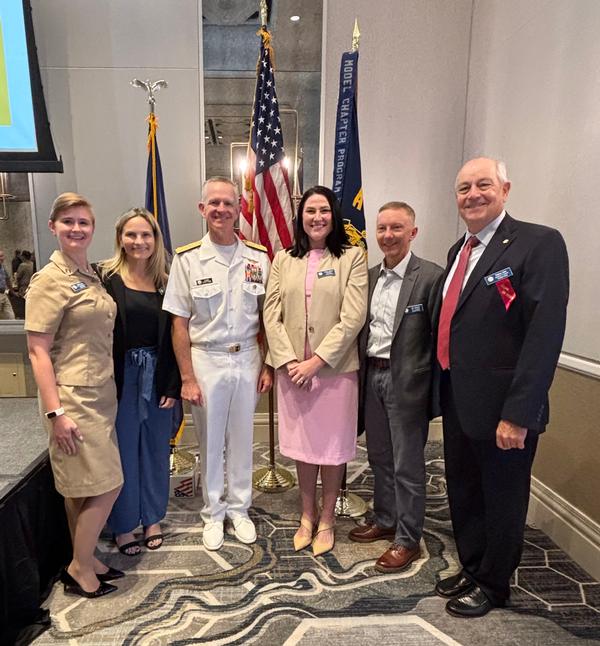 Members of the board of directors stand with Vice Adm. Daniel Dwyer at the July event.