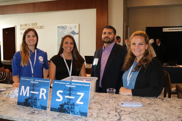 Volunteers (l-r) Liz Hawker, Candice Cobb, Zeib Parvez and Kelly Jenne staff the IT summit information booth at the June Maritime IT Summit.