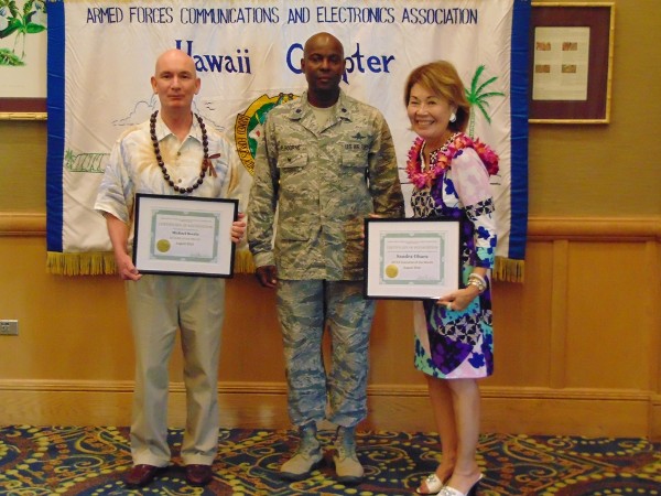 At the August luncheon, Chapter Executive Vice President Lt. Col. Callistus Elbourne, USAF (c), honors Michael Boutte, software engineer for Lockheed Martin, as AFCEAN of the Month and Sandra Ohara, director of corporate accounts for Adecco, as Executive of the Month.