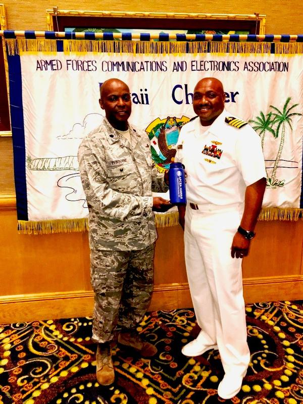 Chapter President Lt. Col. Callistus Elbourne, USAF (l), presents a token of appreciation to May guest speaker Capt. Herman Archibald, USN.