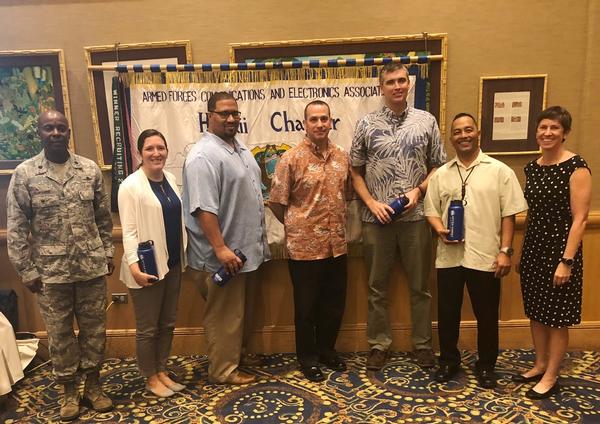 Lt. Col. Callistus Elbourne, USAF, chapter president (l), and Christine Lanning, chapter vice president of programs (r), pause for a photo with October panelists (from 2nd from l) Ashley Hillard, Shawn Case, David Cohen, Chris Jensen and James Cruz.