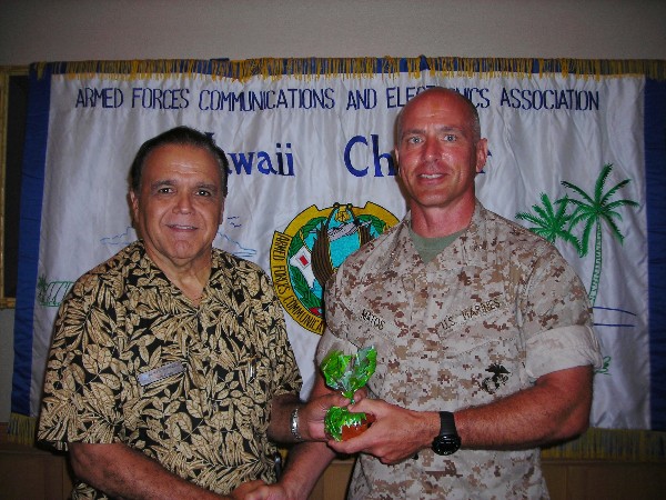 In July, Cory Lindo, chapter president, greets luncheon speaker Col. Joseph A. Matos III, USMC, commander, Defense Information Systems Agency, Pacific.
