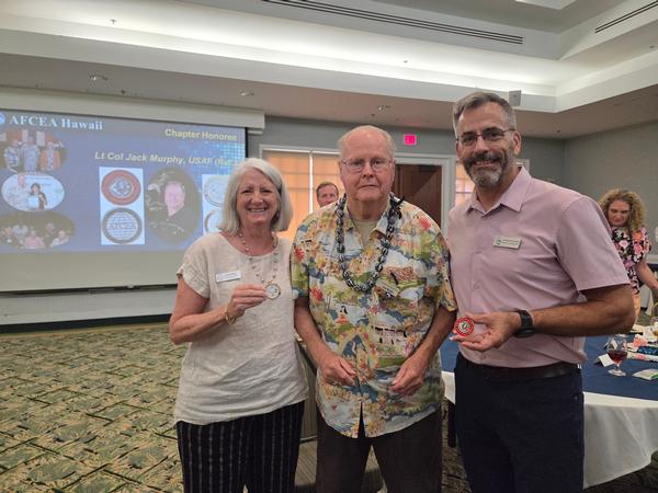 In August, Regional Vice President Linda Newton presents Murphy (c) with her AFCEA International Regional Vice President's coin. On behalf of Lt. Gen. Susan S. Lawrence, USA (Ret.), president and CEO of AFCEA International, Hawaii Chapter President Dick Palmieri presents Murphy with her coin of excellence.