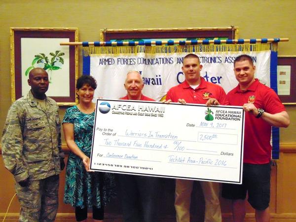 Chapter President Lt. Col. Calistus Elbourne, USAF (l), and last year's TechNet Asia-Pacific director Cynthia Pacheco present Wounded Warrior Chaplain Steve Jensen (c), accompanied by Staff Sgt. Brad Simich, USMC, and Sgt. Kyle Levea, USMC, a $2,500 donation in May. 