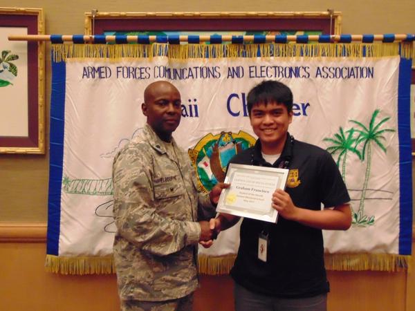 Col. Melbourne (l) honors the chapter's Student of the Month, Graham Franciso, of Damien Memorial School at the May luncheon.