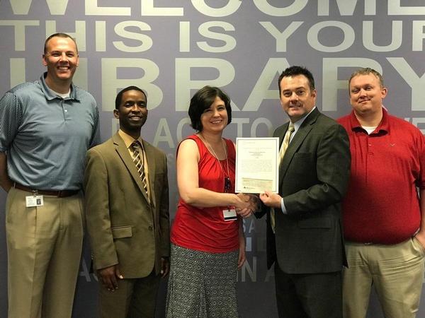 Nivens (2nd from r) awards a grant in May to Madison County High School educators and administrators (l-r) Jeremy Lowry, principal; Perkins; Regina Bennett, assistant principal; and Brody Ballinger, engineering and robotics teacher. 