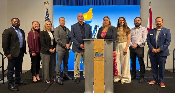 Defense Intelligence Agency (DIA) Missiles and Space Intelligence Center's Director Steven Rush (c) poses with members during the July event. Rush informed a crowd of over 100 attendees on the DIA, modeling and simulation, artificial intelligence utilization and major changes within the organization. 