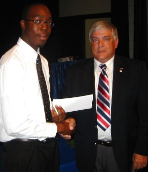 Warren Aliegbe (l) receives the chapter's $2,500 Poling Memorial Scholarship from Vic Budura, chapter president, in May.