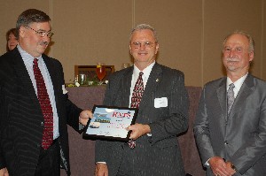 In June, Kenny Watts (c), senior business development manager, Raytheon Company, receives the chapter's Professional of the Year Award from Robert A. Robinson (l), Huntsville Association of Technical Societies president, and Michael Schexanyder, chapter vice president.