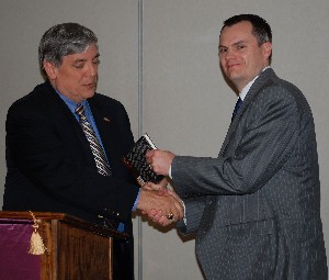 Chad Leathers (r) receives the monthly door price from Budura in March.