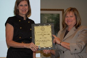 Cynthia Achorn (l), Analytical Services Incorporated, receives a corporate membership certificate from Connie Wallace, chapter vice president for programs, during the July meeting.