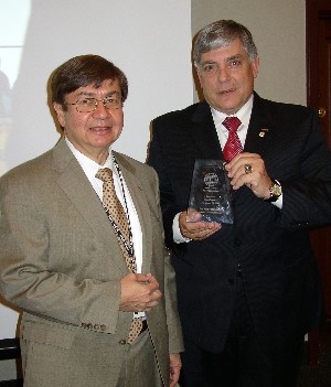 Dr. Kenneth R. Fernandez (l), manager, Advanced Concepts Branch, Science and Mission Systems Office, NASA, Marshall Space Flight Center, Huntsville, Alabama, receives a token of appreciation from Vic Budura, chapter president, for his presentation at the November meeting.