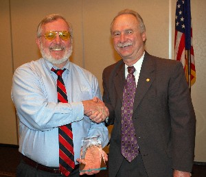 Bill Waite (l), co-founder, chairman and chief technology officer of the AEgis Technologies Group, accepts a token of appreciation from Mike Schexnayder, chapter vice president for programs, in January.