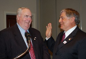 Tom Gwaltney (l), regional vice president, installs Vic Budura as chapter president for a second term during the meeting, held in April.