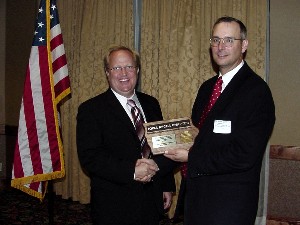 Chapter President Kevin Conley (l) presents speaker John Garstka, OFT, US DOD, with a token of appreciation for sharing information about network-centric warfare with chapter members in September.