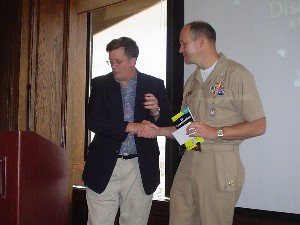 Capt. Bob Whitkop, USN (Ret., l) presents mementos to guest speaker Cmdr. Dave Wirth, USN, in March.