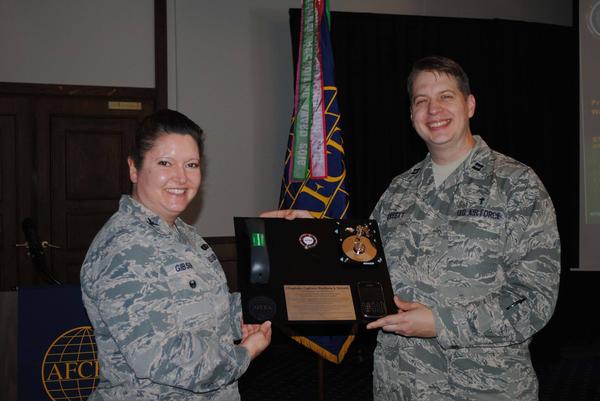 Col. Gibson thanks guest speaker Lt. Col. Matthew Taylor, USAF, with an organizational coin at the May lunch.