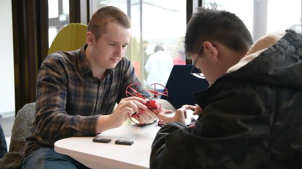 Marc Schlaefer (l) and Isaac Wu, both 11th grade students at Kaiserslautern High School, program a drone at the March event. Photo by: AFN Europe, Sgt. Jacob Slaymaker
