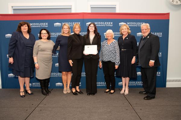 Brianna Caccamesi (c) is awarded the Thomas O'Mahony "Spirit of Excellence" Award by (l-r) Judy Burke, Arlene Rodriguez, Elizabeth Robbins-Murphy, Lorrie O'Mahony-Christo, Claire Goulet, Erin Donlan and Phil Sisson in October.