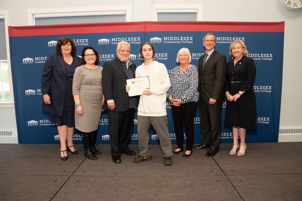 In October, Elijah Harrell (c) is awarded the Claire Goulet Excellence in STEM Award by (l-r) Burke, Rodriguez, Sisson, Claire Goulet, Rich Wissler and Donlan.