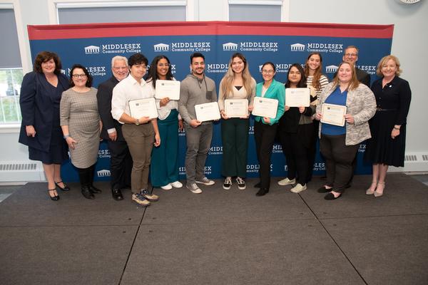(l-r) Burke, Rodriguez, Sisson, Kyle DeCastro, Danisha Ramirez, Anthony Dubey, Maria Mejia, Guzel Saitova, Jessica Pace, Eden Vachtel, Megan Guros, Wissler and Donlan pose for a photo during the October award ceremony. The students were awarded $2,000 scholarships during the event.
