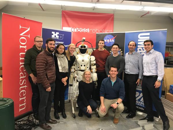 In November, Joyce Sidopoulos, co-founder of MassRobotics (front l), and Will Keller, YAC industry vice president (front r), are pictured with a group of chapter YACs in front of the NASA Valkyrie robot—just one of many robots that startups in the MassRobotics shared workspace may use to test out their innovations.  