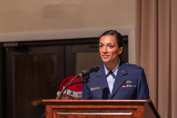Capt. Rachel Szall, USAF, master of ceremonies, welcomes guests to the chapter's December social and presentation of annual Unsung Hero awards. 