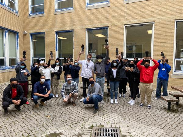 In April, Boston Community Leadership Academy and New Mission High School students and educators join in a group photo to display the robotic hands they constructed and programmed during Robo Week 2021. 