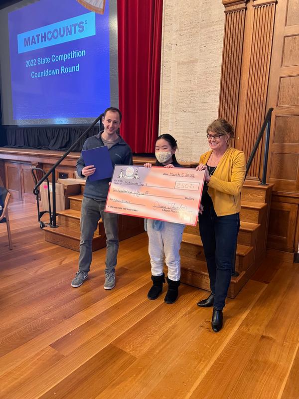 In March, Evan Gaj, emerging leader, philanthropy chair (l), and Mich Cimino, chapter vice president, Administration and Controls, present a $250 check to Selena Ge, Blanchard Middle School, Westford, and congratulate her for being one of the top four winners (and the only female) of the Massachusetts State MATHCOUNTS competition this year.�
