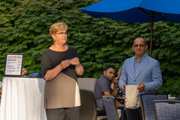 Gretchen Stewart, incoming chapter president (l), assisted by Marco Zompetti, chapter vice president of membership, calls raffle prize numbers for lucky winners at the conclusion of the August event. 