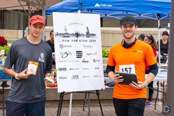 The 5K Run for STEM overall winner, Evan Gaj, who also helped organize the race, receives first place trophy from co-director Will Keller (r) during the post-race festivities in September.
